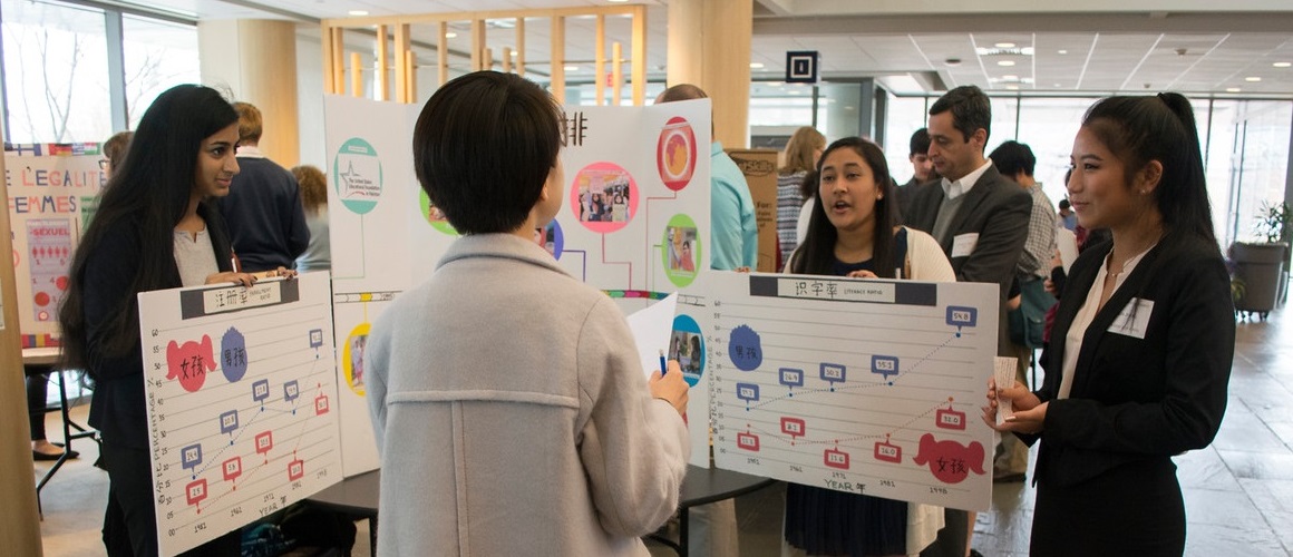 Three students explain their project to a judge at the 2016 Learning Through Languages competition.